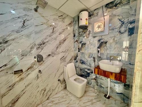 a bathroom with a white toilet and a sink at Shree Krishna Palace Hotel - Couple Friendly in Lucknow