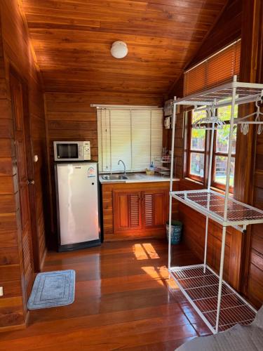 a kitchen with a white refrigerator and a stove at Golden Teak Resort Baan Sapparot in Kamala Beach