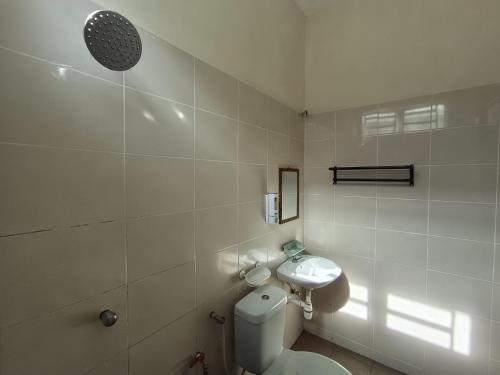 a white bathroom with a toilet and a sink at Lynn Homestay Alor Setar in Alor Setar