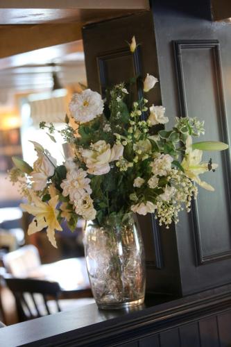 a vase filled with flowers sitting on a table at The King's Head Inn - The Inn Collection Group in Great Ayton