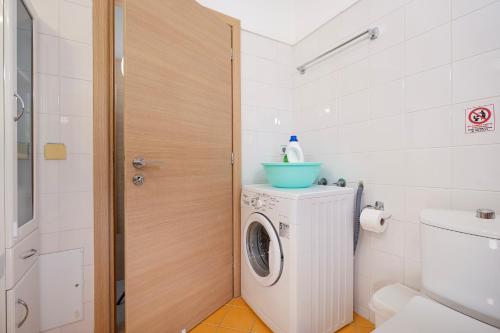 a bathroom with a washing machine and a toilet at Villa Memories in Palaiochora