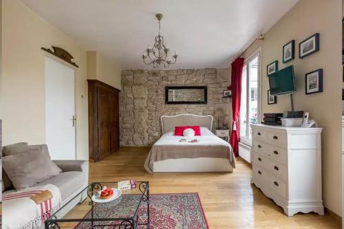 une chambre avec un lit et un mur en pierre dans l'établissement Studio Saint Louis en Ile, à Paris