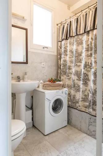 une salle de bain avec une machine à laver et un lavabo dans l'établissement Studio Saint Louis en Ile, à Paris