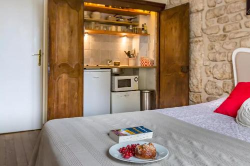 une table avec une assiette de nourriture sur un lit dans l'établissement Studio Saint Louis en Ile, à Paris