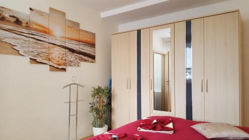 a bedroom with a bed with a red blanket at Ferienwohnungen Villa Waldblick in Zempin