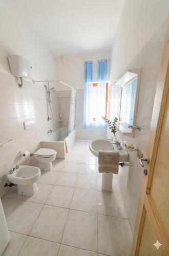 a bathroom with two toilets and a sink and a tub at Casa dei mille in Castelsardo