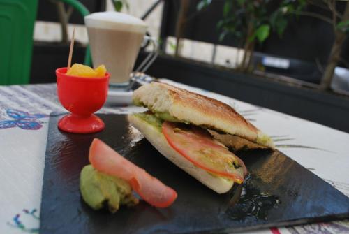 Dos sándwiches en un plato negro con una taza de café. en Apartamentos Larga 70, en El Puerto de Santa María