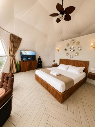 a bedroom with a large bed and a couch at Casa de Monique Glamping Resort in Bogor