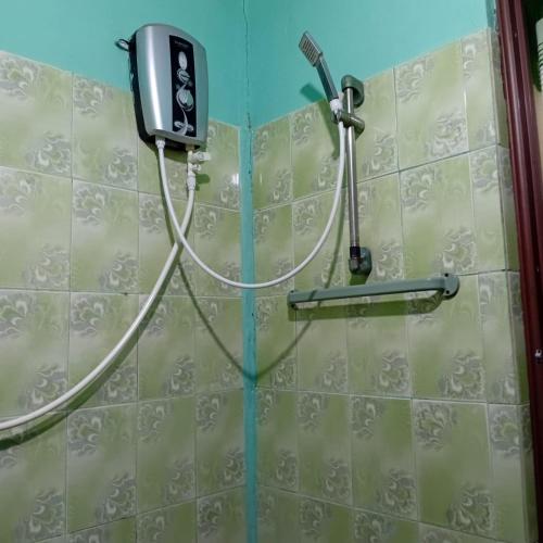 a shower with a hose attached to a wall at Kalana Homestay in Sigiriya
