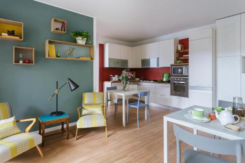 ミラノにあるVivere Milano Isolaのキッチン、リビングルーム(テーブル、椅子付)
