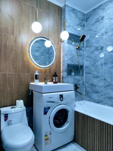 a bathroom with a washing machine and a bath tub at Taraz in Taraz