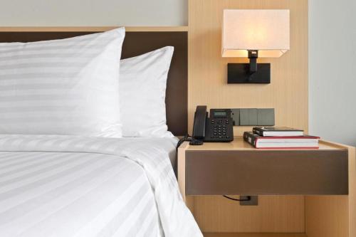 a bed with a lamp and a phone on a night stand at Arena Resort Cam Ranh in Cam Ranh International Airport
