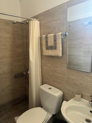 a bathroom with a white toilet and a sink at Annalisa Studio & Apartments in Skala