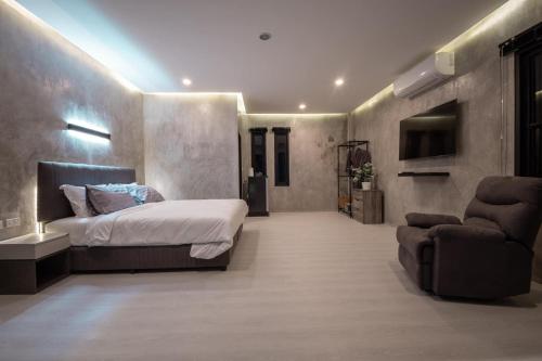 a large bedroom with a bed and a chair at Ma PoolVilla Khanom in Khanom
