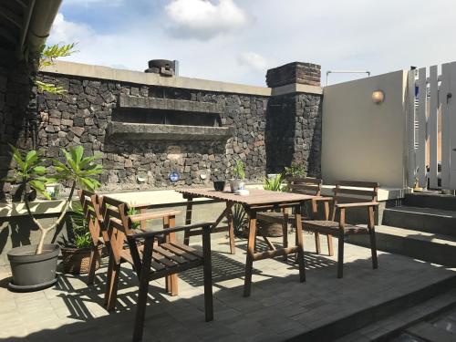 einen Holztisch und Stühle auf einer Terrasse in der Unterkunft Spiegel Home Studio in Semarang