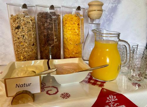 a table with a tray of food and a jug of orange juice at Haus Bodenwinkler in Gröbming