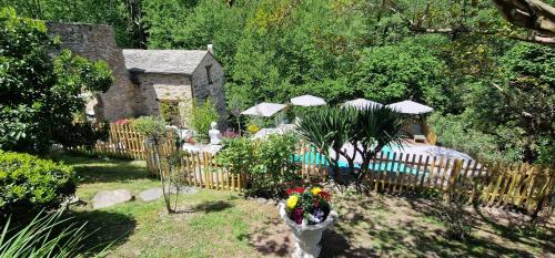 ein Garten mit Holzzaun, Tischen und Sonnenschirmen in der Unterkunft Stalla in Ortiporio