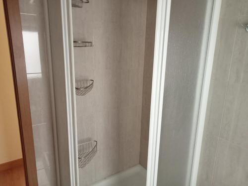 a shower with two shelves in a bathroom at Donato in Gijón