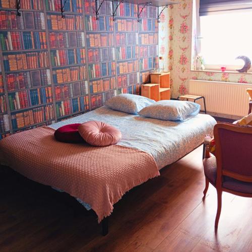 a bedroom with a bed with a wall of books at Emporium in Lobbes