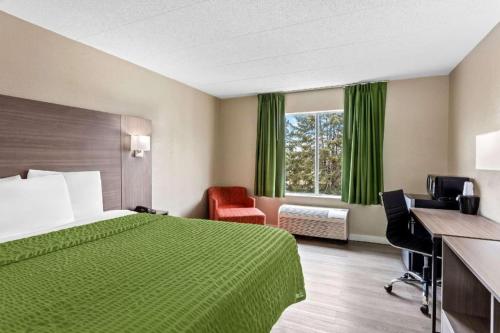 a hotel room with a green bed and a window at Econo Lodge Willowbrook in Burr Ridge