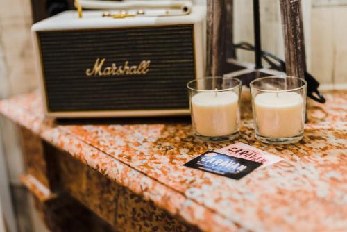 two glasses of milk on a counter with an old radio at Pensión Boutique Caravan Cinema in Bilbao