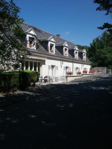 a large white house with flowers on the windows at Le Pigeonnier in Saint-Martin-le-Beau
