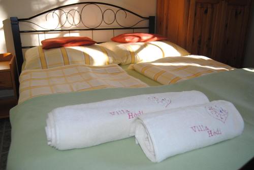 two rolls of white towels on a bed at Villa Hedi in Dunakiliti