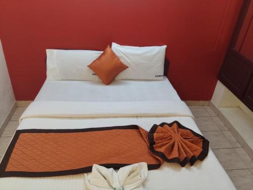 a bed with two white pillows and a brown and white blanket at R K Residency Formerly Gamas in Trivandrum