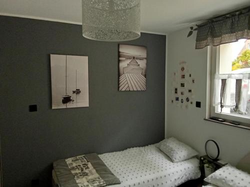 a bedroom with a bed and pictures on the wall at Au petit bonheur chez l'habitant in Ferques