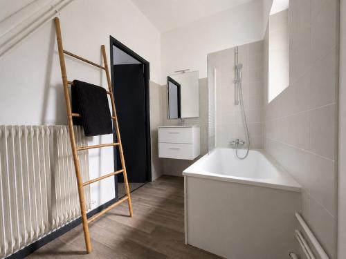 a bathroom with a white tub and a sink at Le Balcon in Montargis