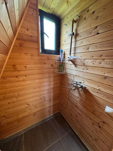a bathroom with a wooden wall with a window at Hochaladah2 in Mestia