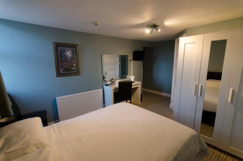 a hotel room with a bed and a desk and a bedroom at Arundel House in Whitby