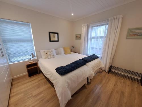 a bedroom with a large white bed and a window at 5 Ysterklip Close, Hermanus in Hermanus