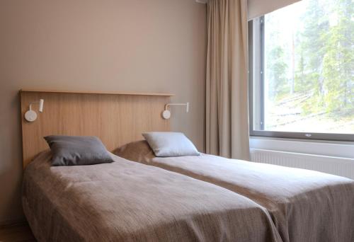 a bedroom with two beds and a window at Ride & Glide Ylläs, lakanat ja loppusiivous sisältyvät in Ylläsjärvi
