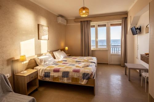 a bedroom with a bed with a view of the ocean at Marea Blue Seaview Apartments of Santa Barbara in Marathias