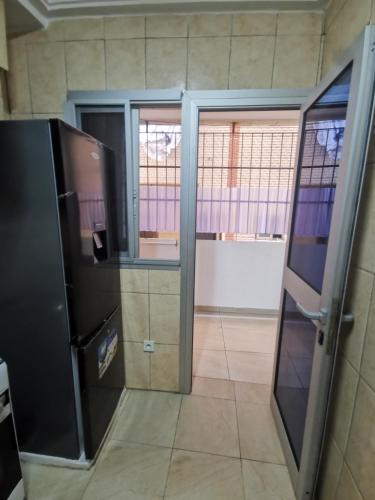 an open door to a room with a refrigerator at Studio VIP - 01 chambre - Bonamoussadi groupe électrogène - 2douches in Douala
