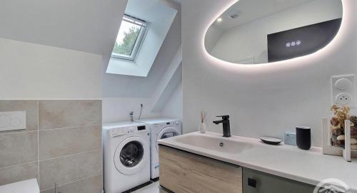 a kitchen with a washing machine and a sink at Gîte La Parenthèse in Troguéry