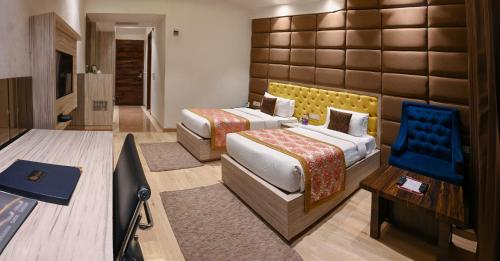 a hotel room with two beds and a television at The Orlov in Babarpur