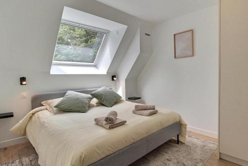 a bedroom with a bed with towels on it at Gîte La Parenthèse in Troguéry