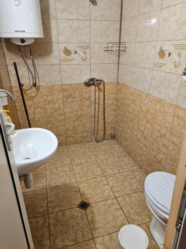 a bathroom with a shower with a toilet and a sink at Вила ДАР in Gara Oreshets