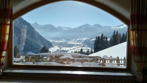 a window with a view of a snow covered mountain at Chalet Schröckgut in Bad Hofgastein