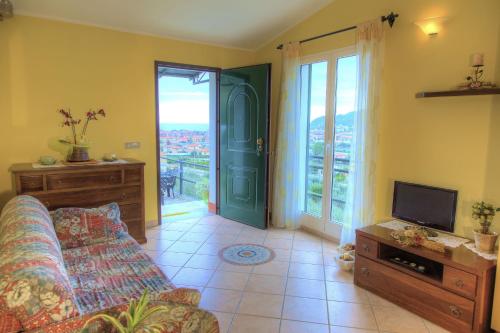 a living room with a couch and a tv at Casa Ilaria in Diano Marina
