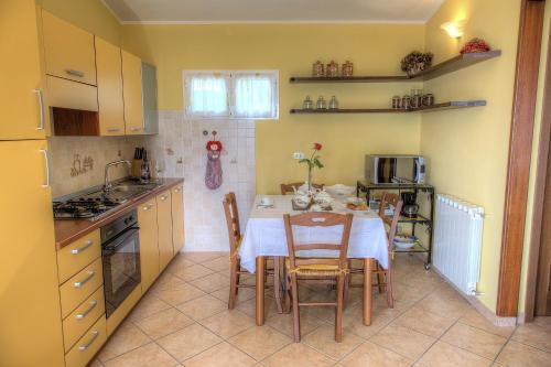 uma cozinha com uma mesa e cadeiras numa cozinha em Casa Ilaria em Diano Marina