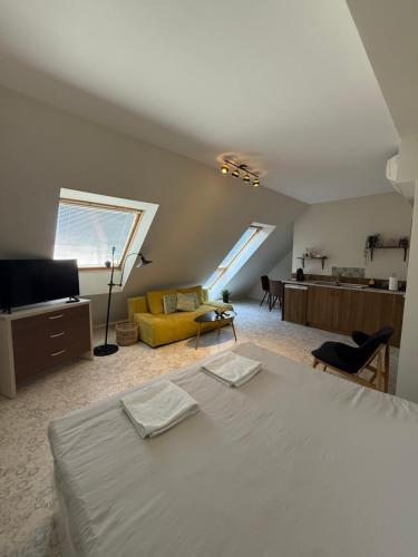 a bedroom with a bed and a yellow couch at Sunny Gym Studio Apartment in Burgas
