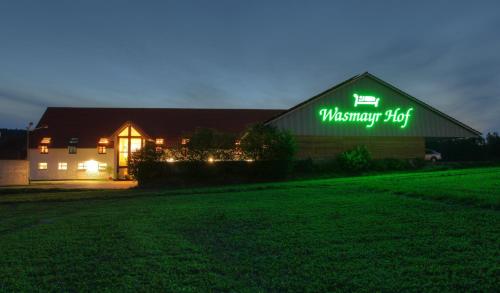 a barn with a green sign on it at night at Wasmayr Hof in Landshut