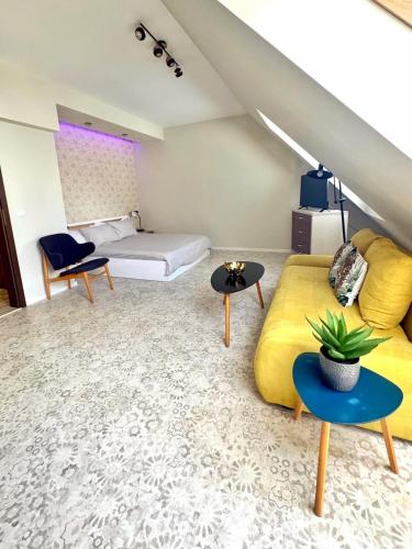 a living room with a yellow couch and a bed at Sunny Gym Studio Apartment in Burgas