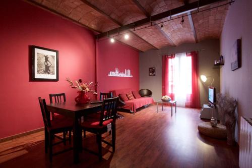 a living room with red walls and a table and chairs at Charm Rambla Catalunya in Barcelona