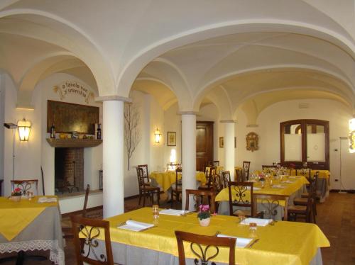 a restaurant with yellow tables and chairs and a fireplace at Villa Schiavi in Sermide