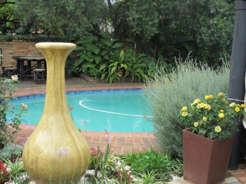 a large vase sitting next to a swimming pool at Ukarimu Guest House in Klerksdorp