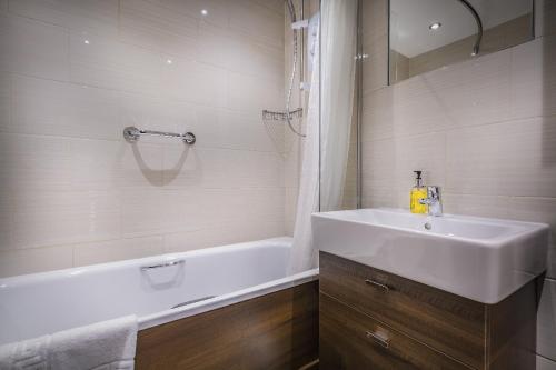 a bathroom with a sink and a bathtub and a sink and a mirror at The Old Bridge Inn, Holmfirth, West Yorkshire in Holmfirth